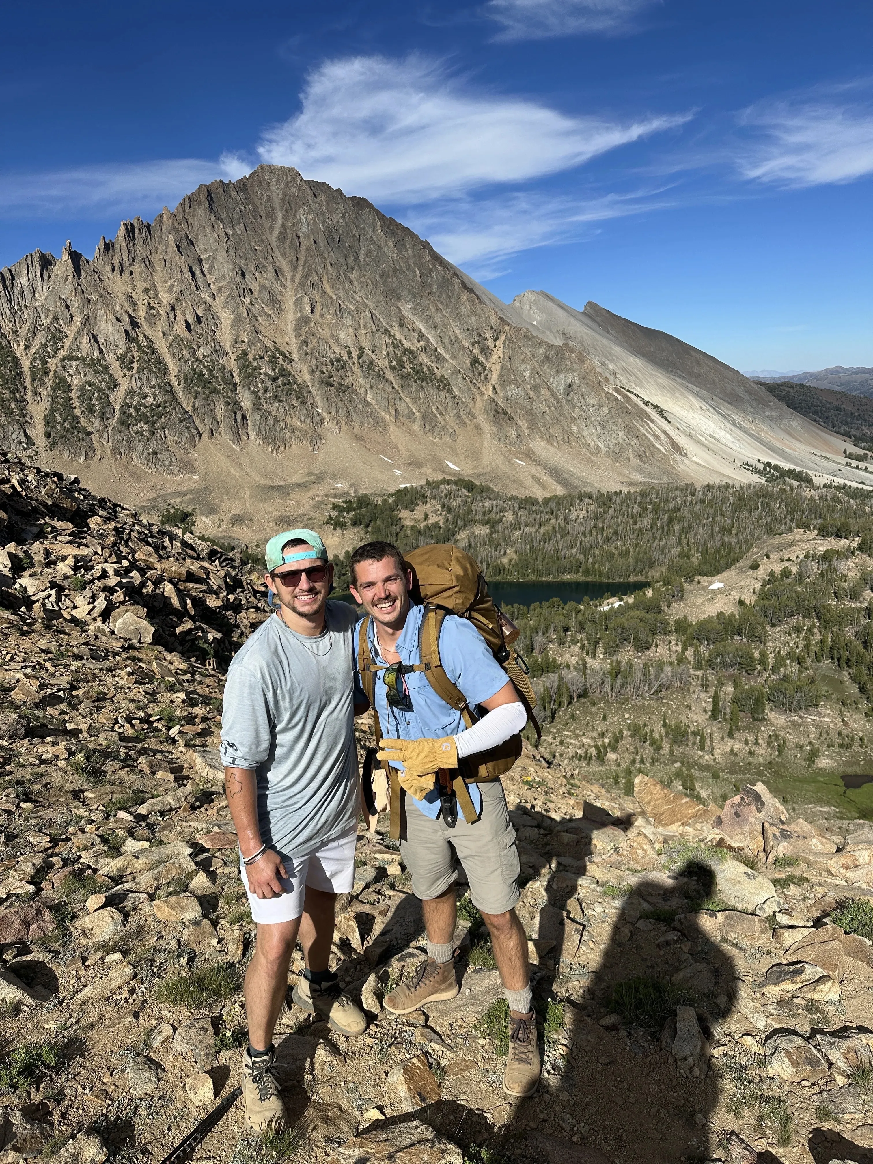 Two hikers on a rocky ridge above an alpine lake