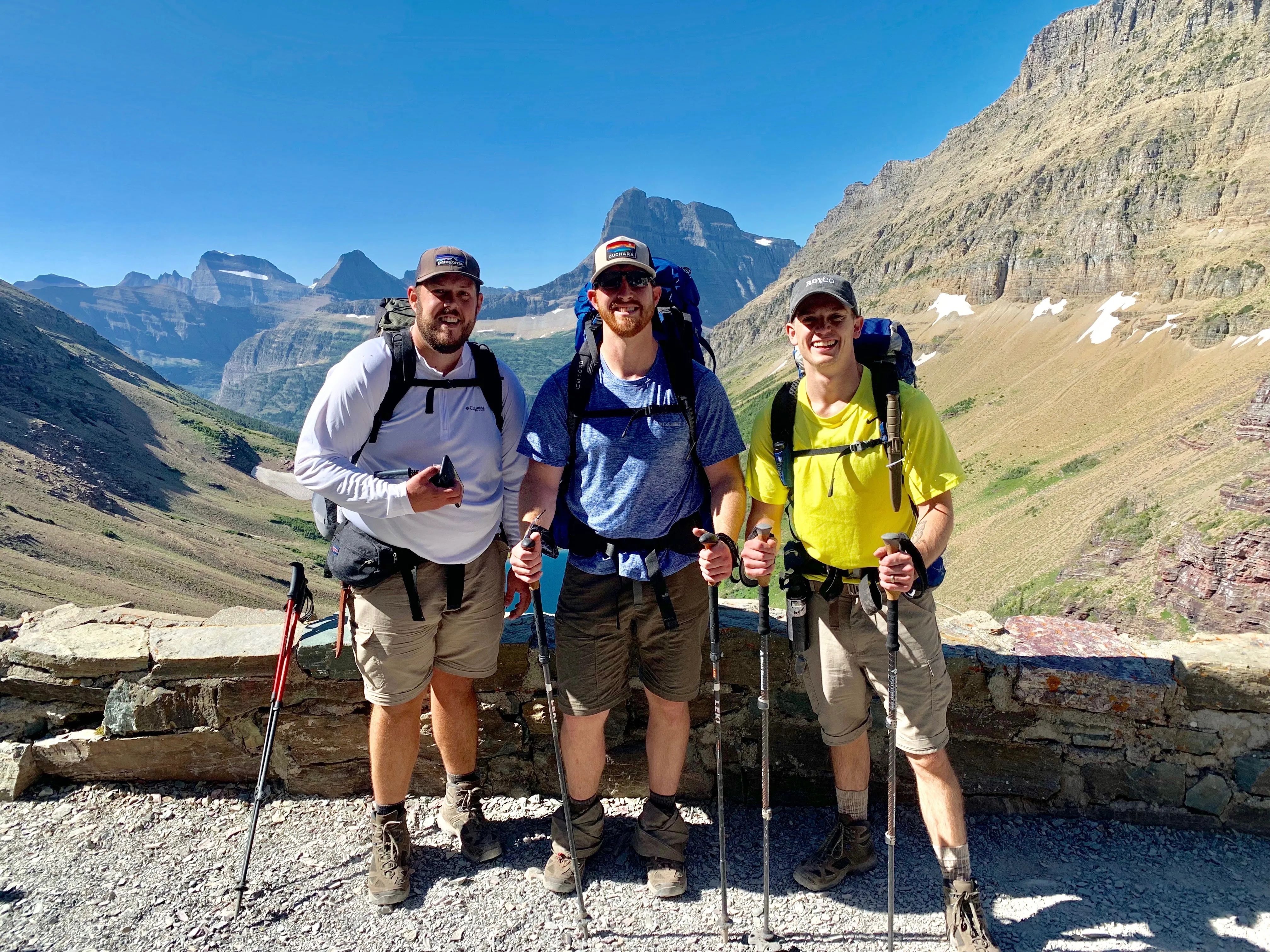 Three backpackers posing with a mountain vista behind them